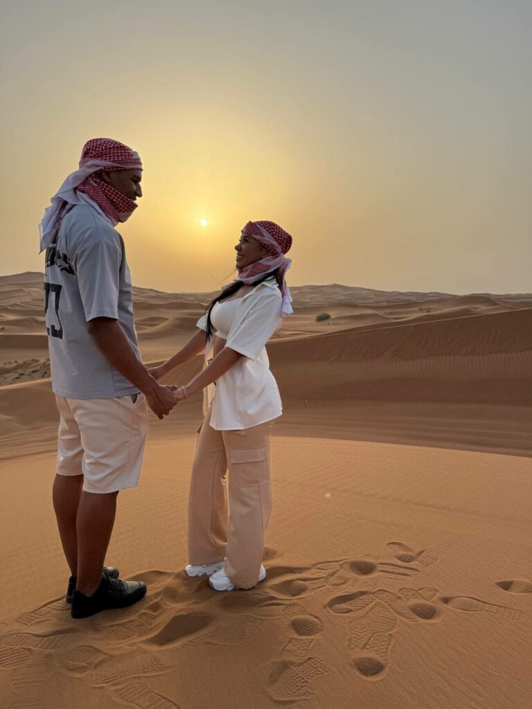 Casal no deserto de Dubai ao pôr do sol, no safári VIP